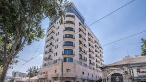 Um edifício de vários andares com fachada curva, com varandas e grandes janelas.