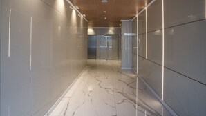 Um corredor moderno com paredes brancas e brilhantes e piso de mármore.