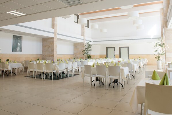 A spacious indoor dining area with multiple round tables and chairs, arranged in rows. - HI Akko Hostel (Acre)