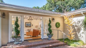 A house with a covered porch, a brick entrance, and a welcome mat.