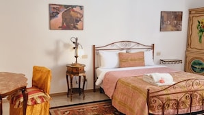 A bedroom with a bed, a chair, a small table, and a rug. - BnB 95mo (Lecce)
