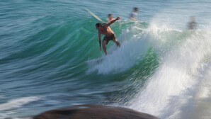 Un surfista montando una ola en el océano.