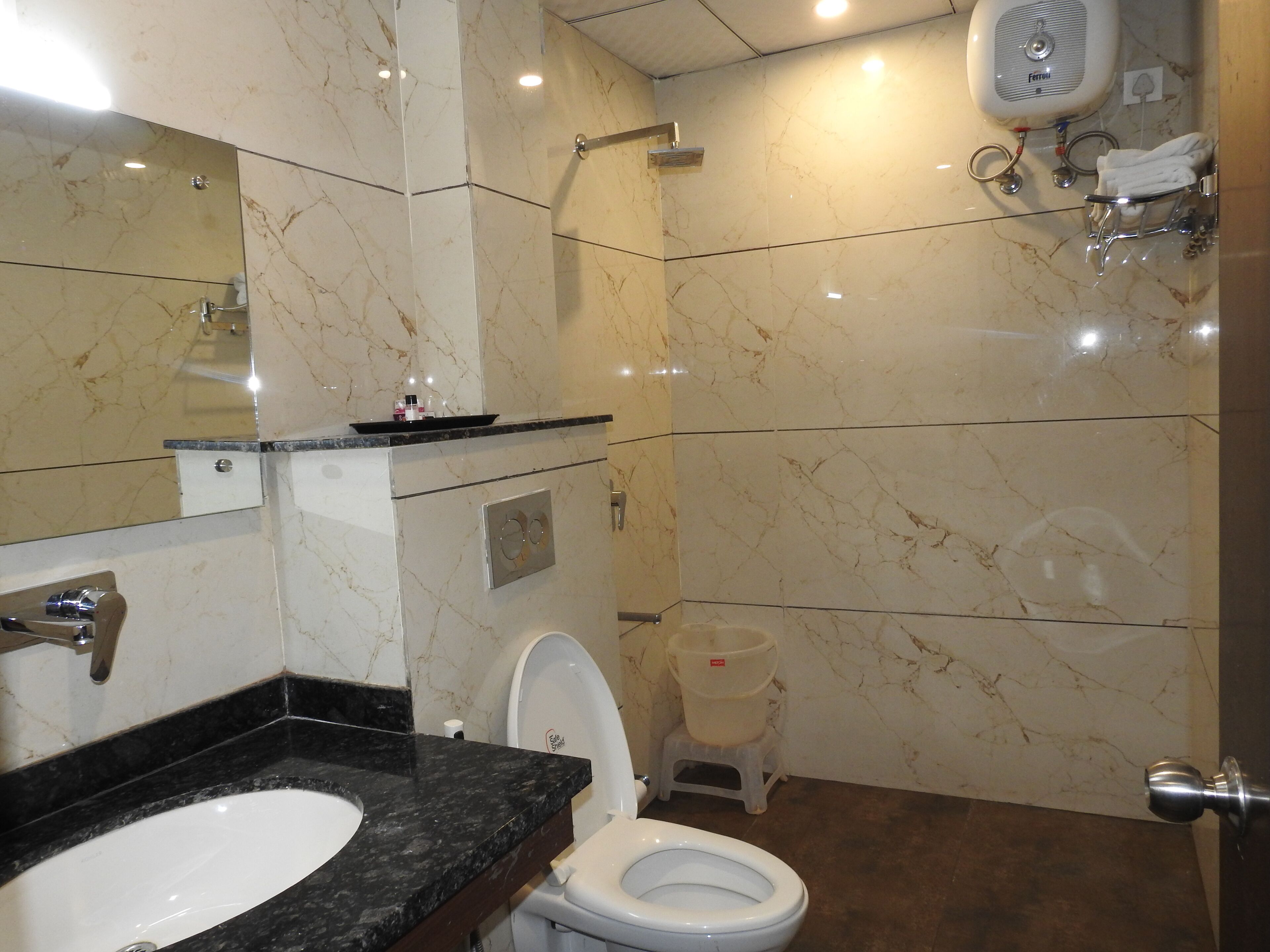 Un bagno con pavimento in marmo, un lavandino, un water e una doccia.