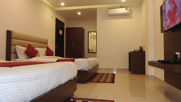 Une chambre d’hôtel avec deux lits, une télévision, un ventilateur de plafond et un appareil de climatisation.