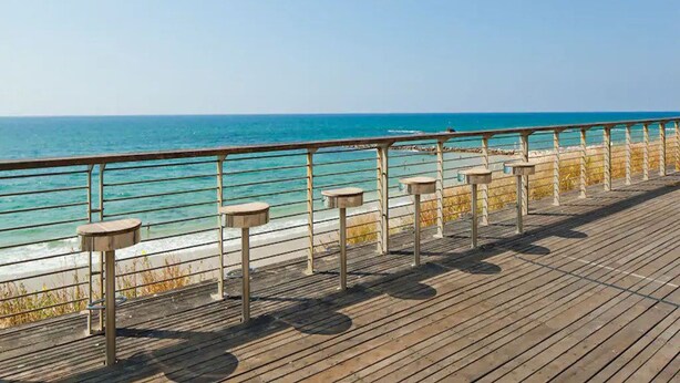 A wooden boardwalk with a metal railing, leading to a beach with clear blue water. - 3BR Apt Beach View Best Loc Bat-Yam (Bat Yam)