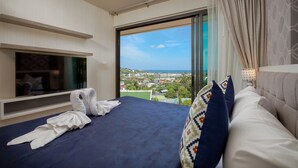 A hotel room with a bed, a TV, and a large window offering a city view. - Splendid Sea View Resort (Karon)