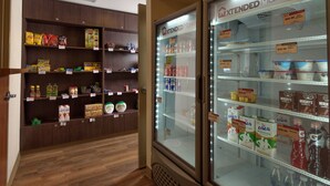 Ein Hotelzimmer mit Holzboden, einer Minibar und einem Kühlschrank, der mit Getränken und Snacks gefüllt ist.
