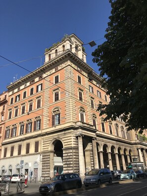A historic building with classical architecture, featuring multiple arches and columns, and a prominent corner tower. - Kings Home In Rome (Rome)