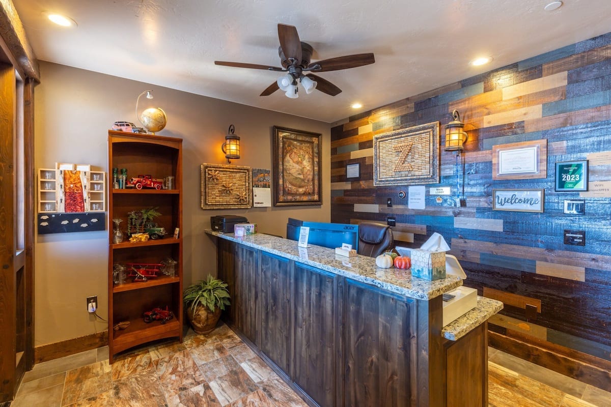 A reception area with a wooden reception desk, a globe on a shelf, and framed artwork on the wall.