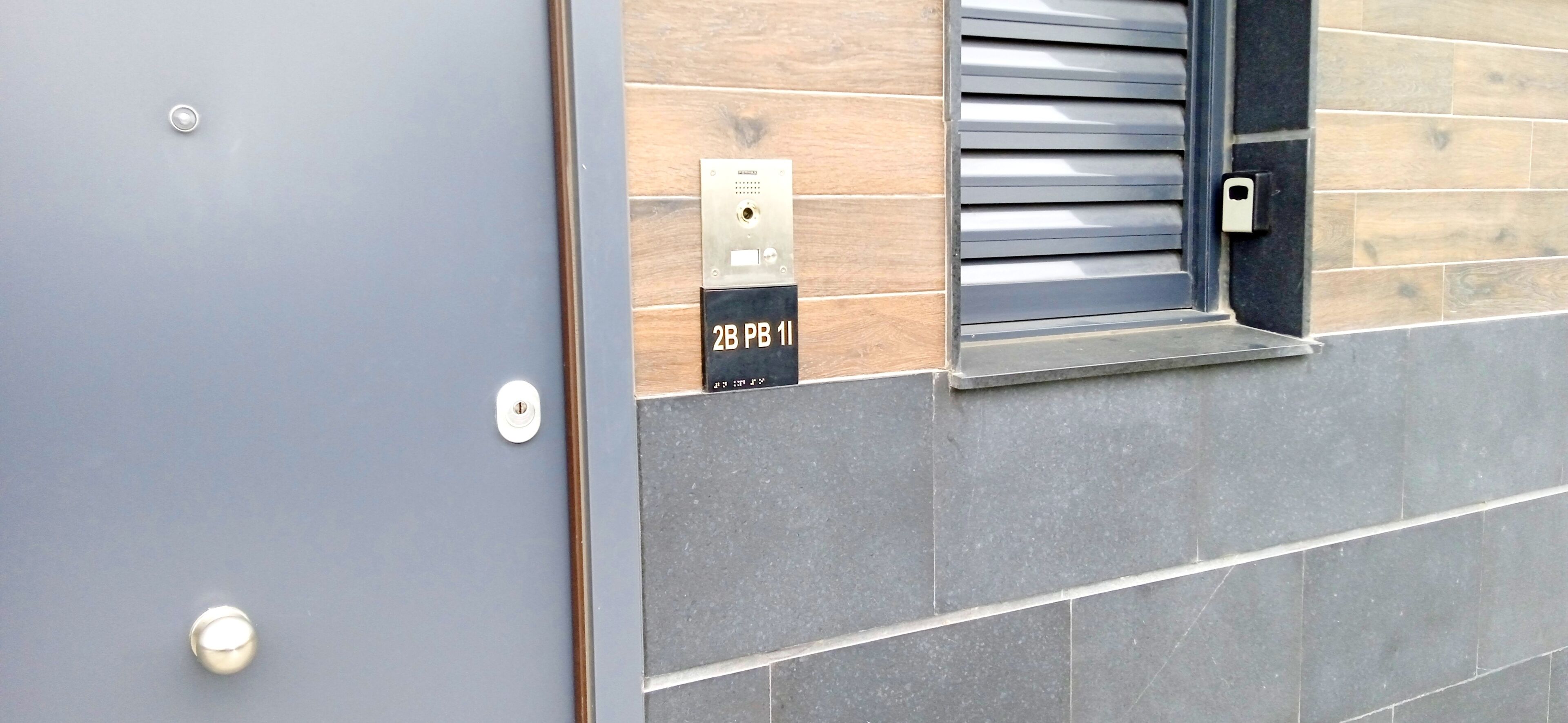 A door with a lock and a keypad with a label "2B PB 1".