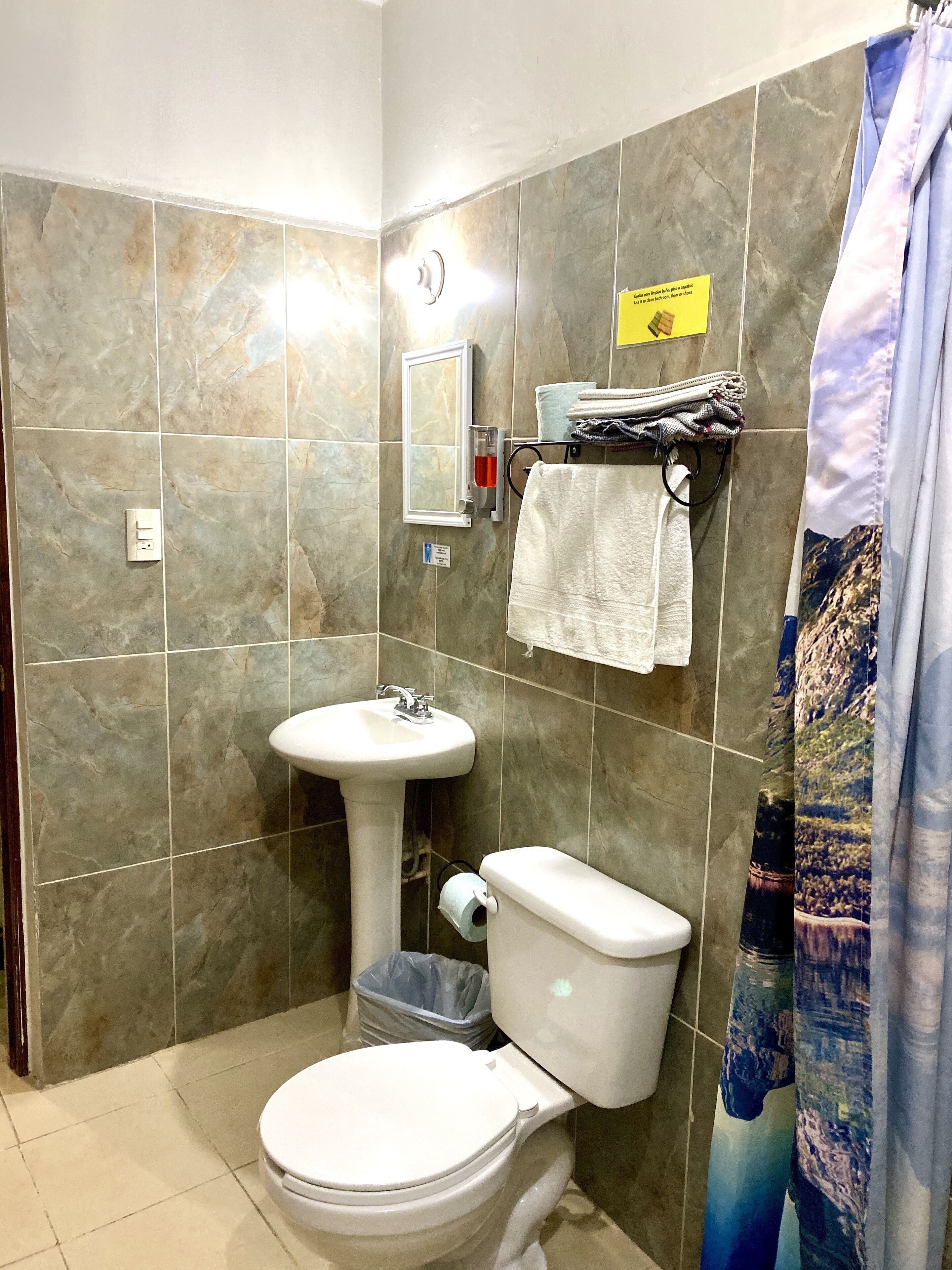 A bathroom with a toilet, sink, and a towel rack.