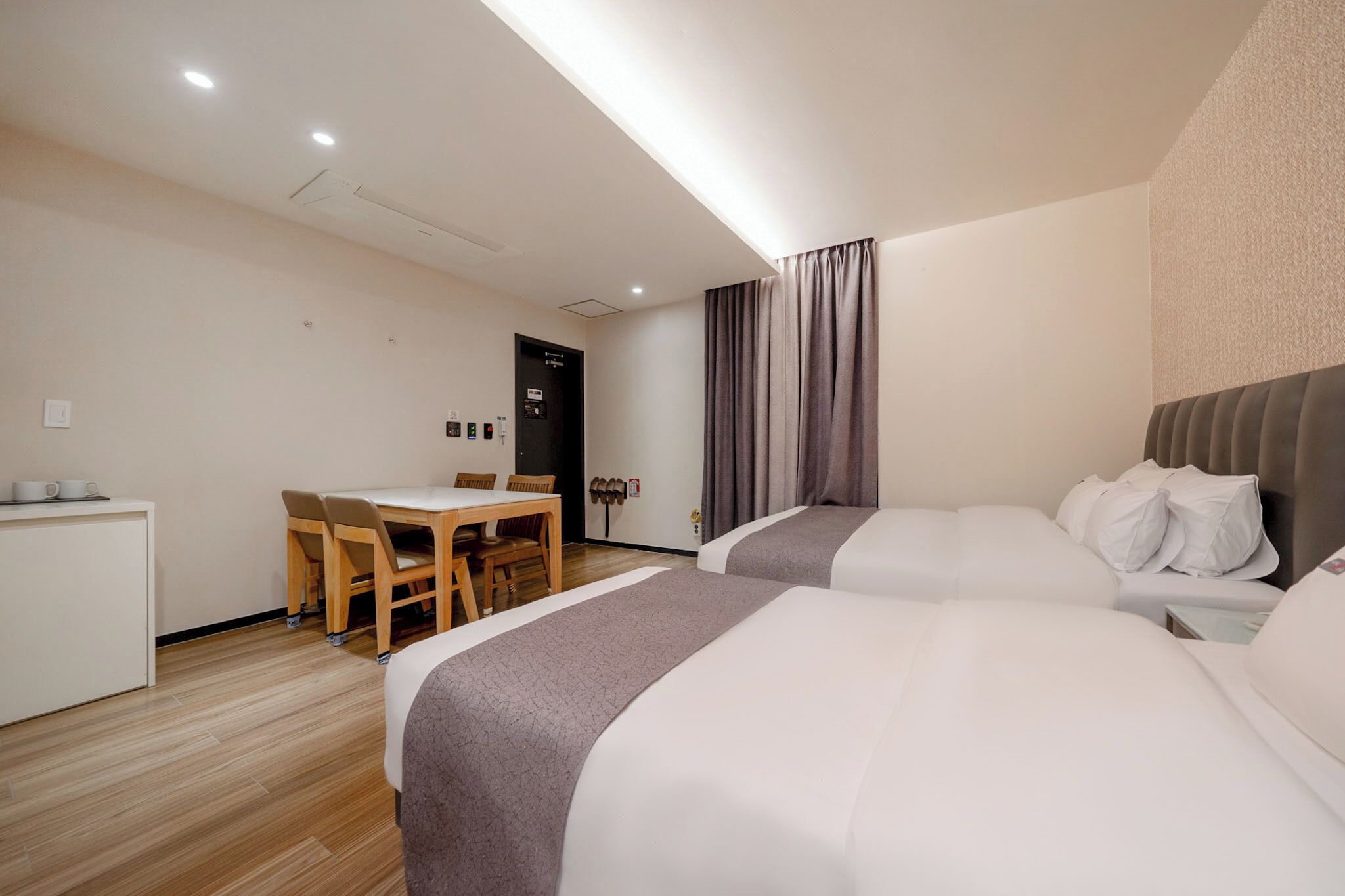 Ein Hotelzimmer mit zwei Betten, einem Schreibtisch und einem Stuhl.
