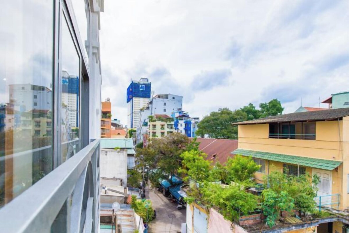 Un quartier résidentiel avec des immeubles, une rue étroite et quelques espaces verts.