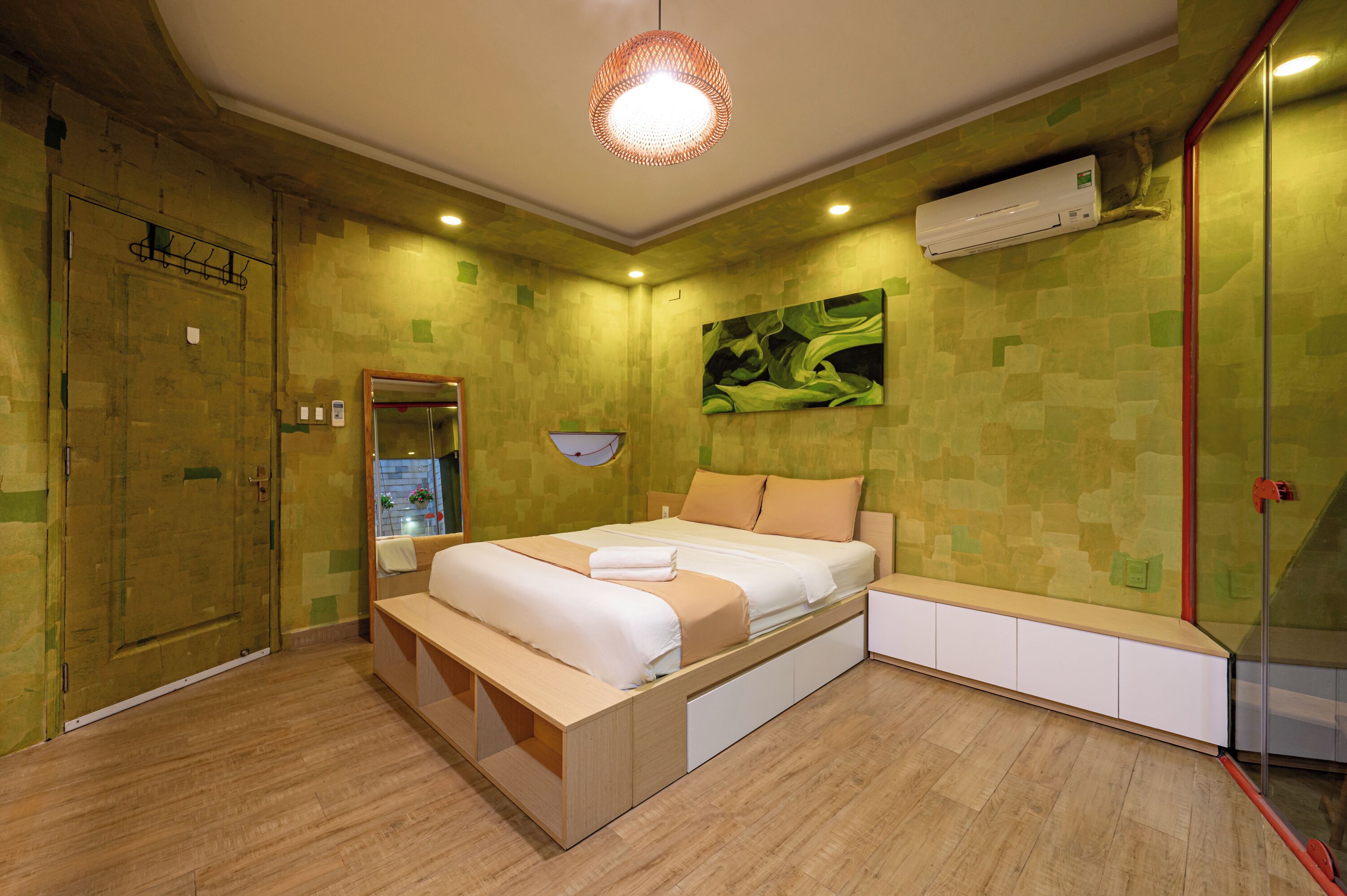 A modern bedroom with a bed, bedside table, and a built-in bench.