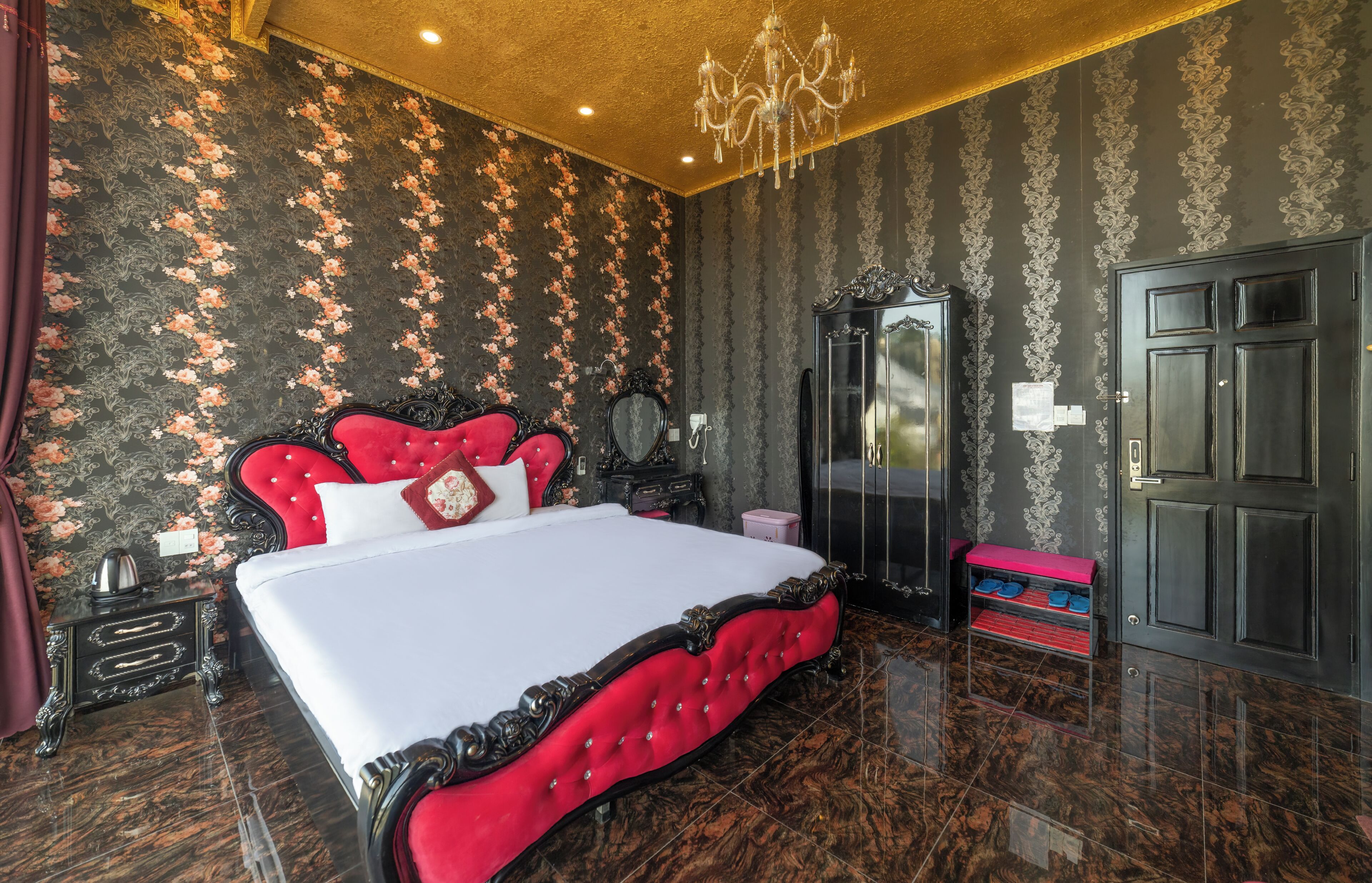 A bedroom with a large bed, a dresser, a mirror, and a door.