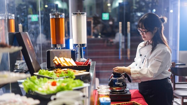 Un buffet proposant une variété de plats et un distributeur de boissons KINX.