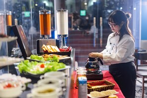 Ein reichhaltiges Buffet mit verschiedenen Speisen und einer KINX-Getränkespender.