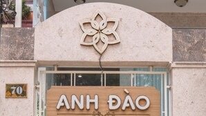 Une enseigne d’hôtel portant le nom « ANH DAO HOTEL », placée au-dessus d’une fenêtre.