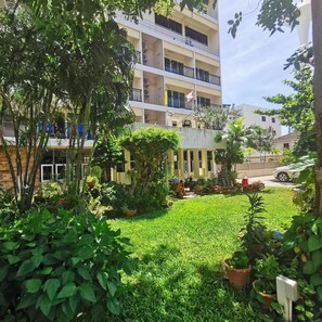 A multi-story building with balconies, surrounded by lush greenery and potted plants. - Subhamitra Hotel Hua Hin (Hua Hin)