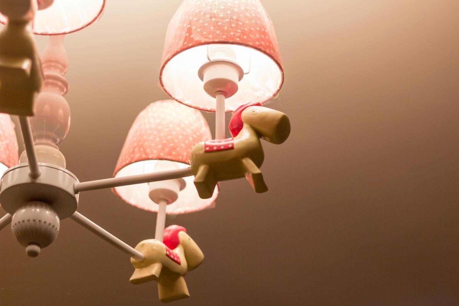 Un plafond orné d’un lustre comportant plusieurs abat-jours et une source de lumière centrale.