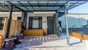 A modern multi-story building with a covered outdoor seating area and a visible entrance. - BJ Classic Town (Wujie)