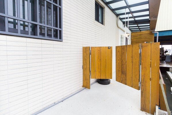 A clean, white building exterior with a metal-framed window and a wooden partition. - BJ Classic Town (Wujie)