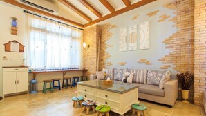 A cozy living room with a sofa, a coffee table, and a brick accent wall. - BJ Classic Town (Wujie)