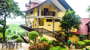 A multi-story building with a balcony, a staircase, and a view of a green landscape. - Punta de Fabian powered by Cocotel (Baras)