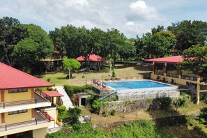 A hotel with a swimming pool surrounded by lush greenery and multiple buildings with red roofs. - Punta de Fabian powered by Cocotel (Baras)