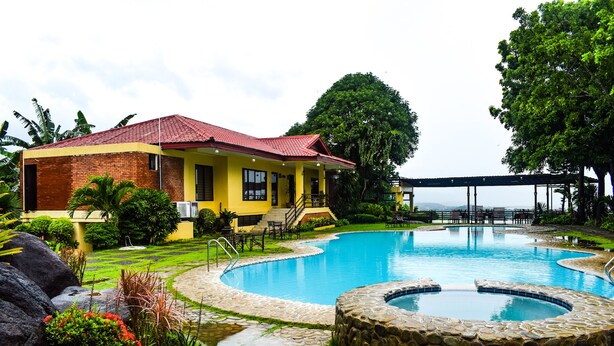 A yellow building with a red roof, a swimming pool, and a stone hot tub. - Punta de Fabian powered by Cocotel (Baras)