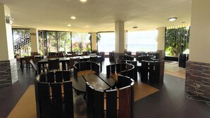 A spacious indoor dining area with multiple tables and chairs, large windows with a view, and a modern ceiling design. - Punta de Fabian powered by Cocotel (Baras)