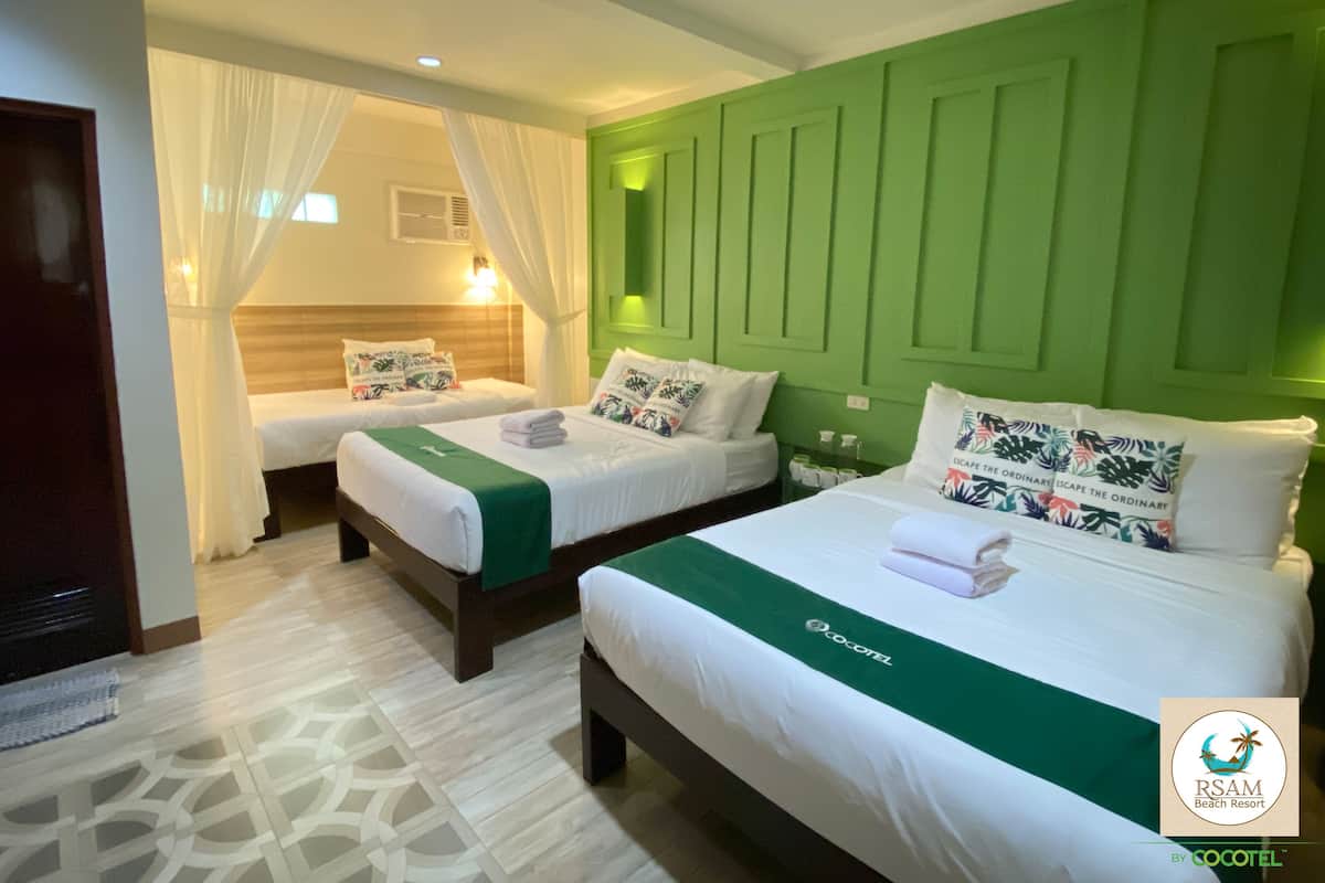 Ein Hotelzimmer mit zwei Betten, grünen Wänden und einem gemusterten Boden.