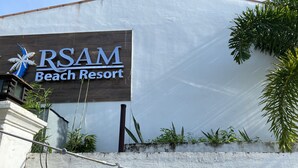 Placa do RSAM Beach Resort com o logotipo de uma palmeira.