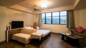 A hotel room with a bed, a sofa, a television, and a window with a view. - Dahua Hotel (Keelung)