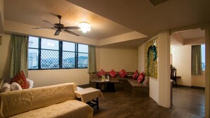A spacious living room with a sofa, a coffee table, and a dining area. - Dahua Hotel (Keelung)