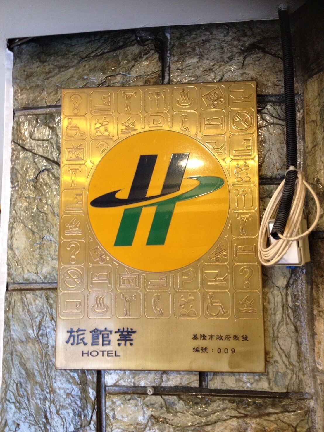 A hotel sign with a large emblem and multiple symbols indicating amenities.