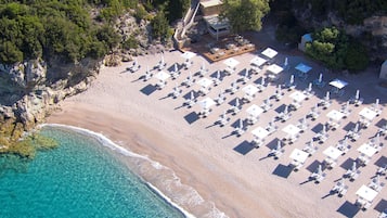 On the beach, white sand, sun-loungers, beach umbrellas
