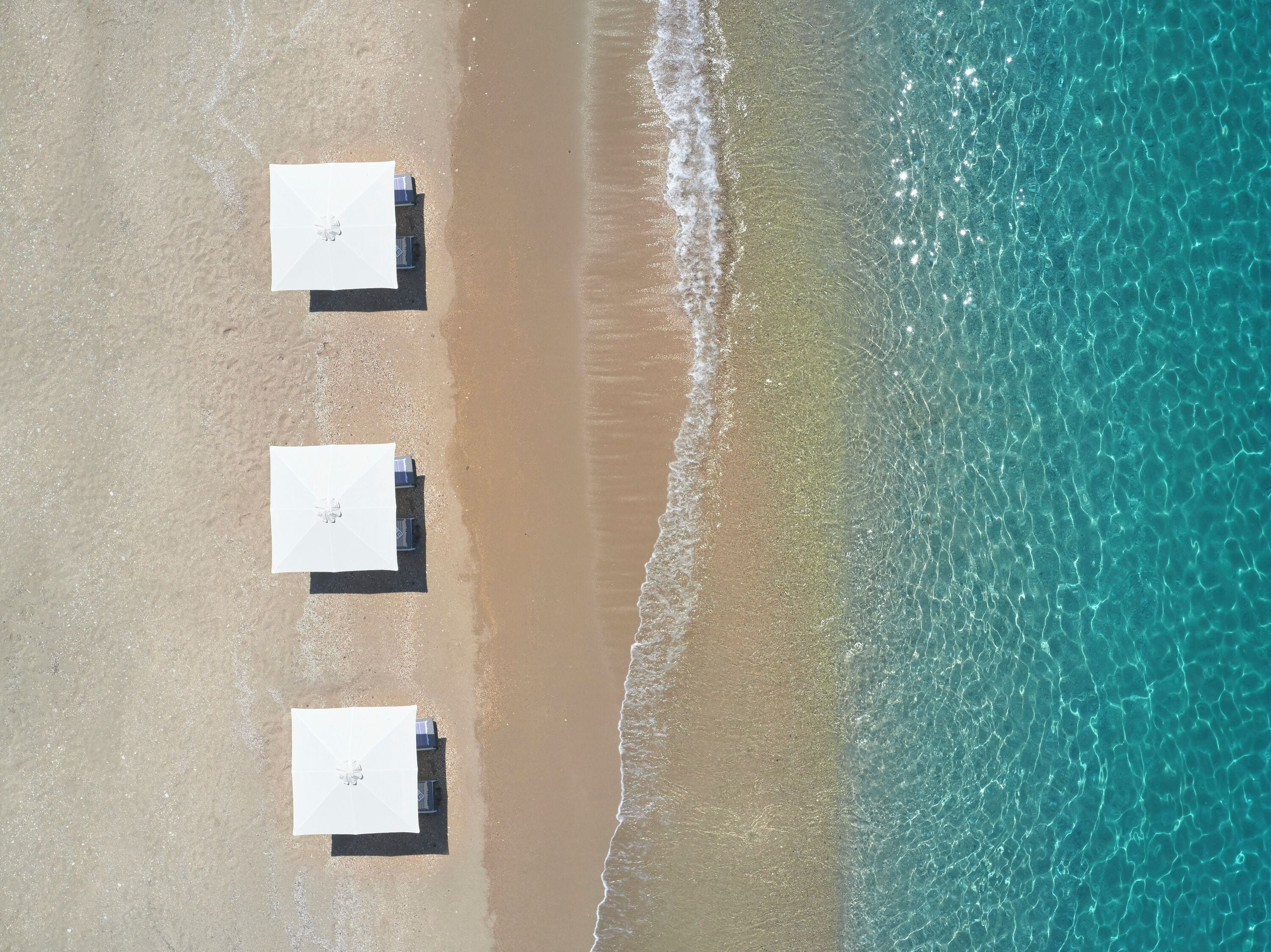 On the beach, white sand, sun-loungers, beach umbrellas