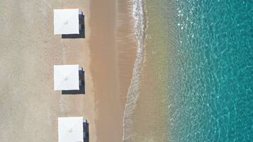 On the beach, white sand, sun-loungers, beach umbrellas