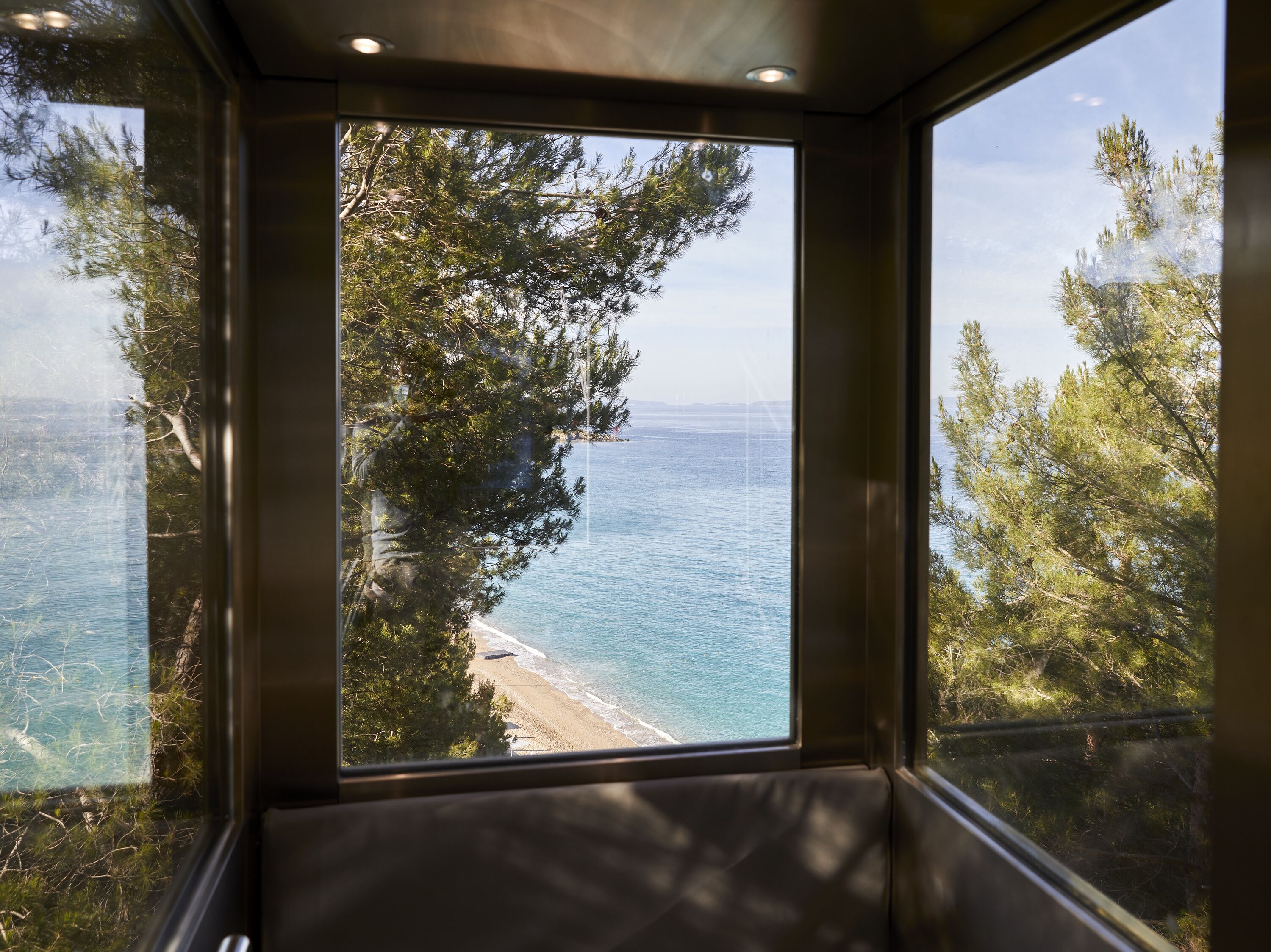 Di pantai, pasir putih, kursi berjemur, dan payung pantai