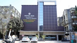 A modern building with a large sign for HOTEL DAN, indicating it offers rooms, banquets, and a restaurant. - Pan Club Hotel (Vapi)