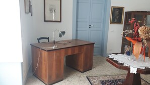 A wooden desk with a lamp, a chair, a framed picture on the wall, and a decorative vase on a table. - Casa Maltese ri Scicli (Scicli)