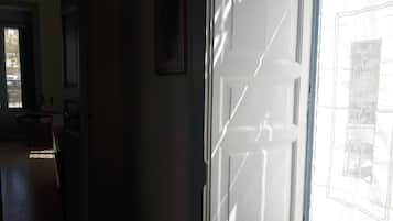 Un pasillo con una puerta que da a una habitación con un ventanal grande.