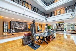 A spacious lobby with a high ceiling, a central round table, and a statue. - Yiu Teung Mansion (Chengdu)