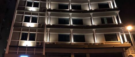 A multi-story hotel with balconies and a prominent 'HOTEL' sign.