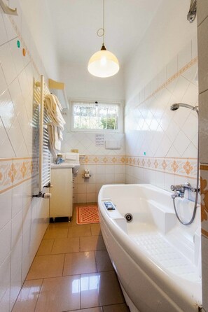 Junior appartement | Badkamer | Een aparte badkuip en douche, een haardroger, een bidet, handdoeken