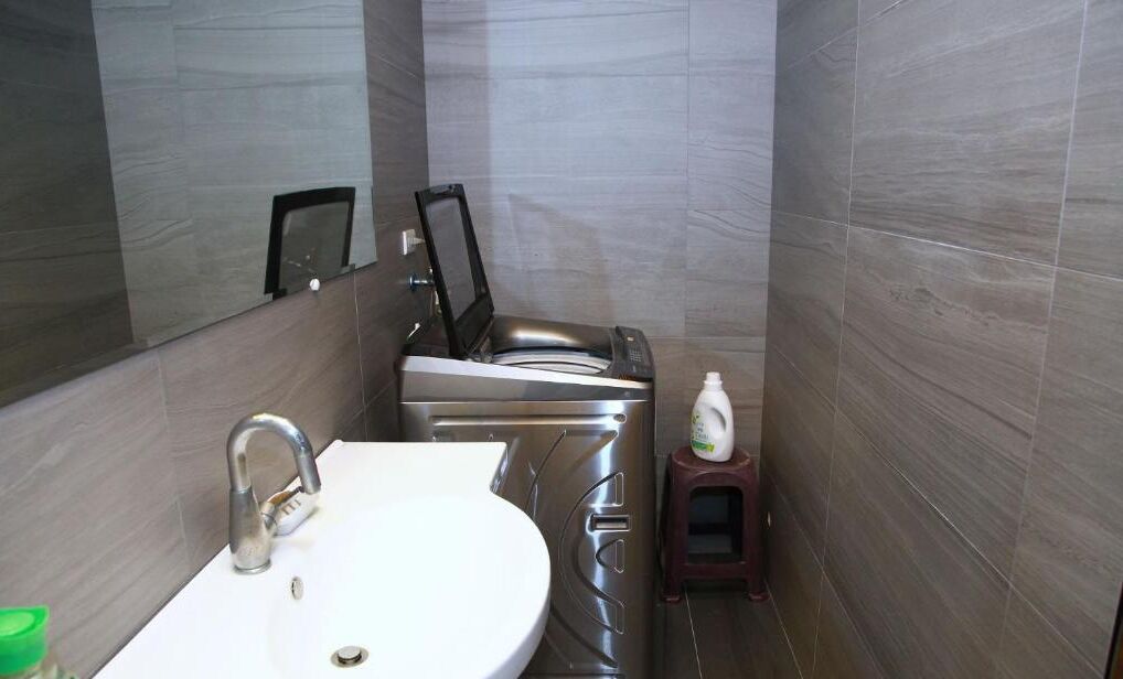 A modern bathroom with a white sink, a mirror, and a toilet.