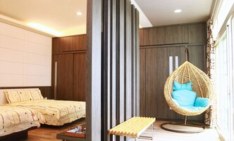 Un dormitorio moderno con una cama, una silla colgante y un banco.