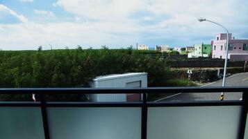 A view from a balcony overlooking a road with buildings in the background.