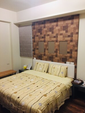 Ein Schlafzimmer mit einem Bett, einem Nachttisch und einer Wand mit einem pixeligen Muster.